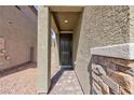 Covered front porch featuring stone accents, pavers and a dark-colored door at 9086 Nostrand Ave, Las Vegas, NV 89148