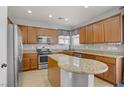Well-lit kitchen featuring tan cabinets, granite countertops, stainless steel appliances and tile flooring at 9190 Wine Cellar Ave, Las Vegas, NV 89148