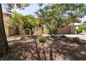 Beautifully landscaped front yard with lush greenery, a mature tree, and a two-car garage at 9329 January Dr, Las Vegas, NV 89134