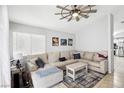 Inviting living room featuring a large sectional, modern ceiling fan, and natural light at 9333 Jumpin Juniper Ave, Las Vegas, NV 89129