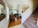 Inviting living room has hardwood floors, stairs, large windows and comfortable seating at 11117 Okeefe Ct, Las Vegas, NV 89144