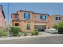 Two-story home showcasing colorful exterior, tidy landscaping, and two-car garage at 1413 Miller Ridge Ave, North Las Vegas, NV 89031