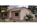 Exterior shot showcasing the tan stucco, red tile roof, and well-maintained landscaping at 1612 N Torrey Pines Dr # 104, Las Vegas, NV 89108