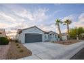 Spacious home with a long driveway, desert landscaping, and a gray two-car garage at 2099 Mountain City St, Henderson, NV 89052