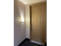 A picture of unit 403's tan front door with a silver handle, and lit by a lamp to the side at 23 E Agate Ave # 403, Las Vegas, NV 89123