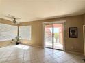 Sunlit living room showcasing tile floors, ceiling fan, and sliding door to the balcony at 23 E Agate Ave # 403, Las Vegas, NV 89123