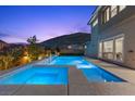 Beautiful pool and jacuzzi with outdoor lighting and mountain views at dusk at 2890 Reverence Heights Ln, Las Vegas, NV 89138