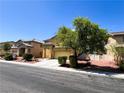 Two story home with a landscaped front yard, driveway, and a beautiful tree at 3412 Catherine Mermet Ave, North Las Vegas, NV 89081