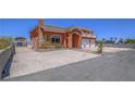 Terracotta-colored two-story home with a gated driveway and a second-story balcony, surrounded by desert landscaping at 420 Dakar St, Henderson, NV 89015
