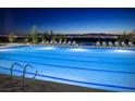 Community pool with illuminated water and lounge chairs at night at 462 Fortissimo St, Henderson, NV 89011