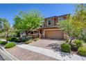 Beautiful home with lush landscaping, mature trees, and a two-car garage at 462 Fortissimo St, Henderson, NV 89011