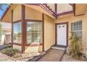 Inviting front entrance featuring a white door, sidelight window, and neatly landscaped flowerbed at 504 Arthur Ave, Henderson, NV 89015