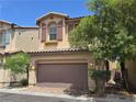 Inviting two-story house featuring a two-car garage, desert landscaping and a tidy walkway at 9312 Gold Dove Ct, Las Vegas, NV 89178