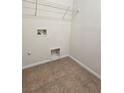 Compact laundry area with tiled floor, wire shelving, and water hookups ready for appliances at 9312 Gold Dove Ct, Las Vegas, NV 89178