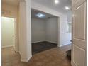 Open living room featuring tile flooring, neutral walls, and an open doorway to a carpeted room at 9312 Gold Dove Ct, Las Vegas, NV 89178