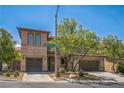 Frontal view of the two-story home showing garage and landscaped front yard at 10373 Hawk Ravine St, Las Vegas, NV 89178