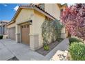 Charming home detail with stucco siding, three car garage, and verdant landscaping at 1127 Lake Berryessa St, Henderson, NV 89002