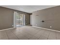 Open living room with neutral walls and tile floors, brightened by natural light at 201 Mission Laguna Ln # 104, Las Vegas, NV 89107