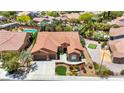 Expansive terracotta roof home with lush backyard featuring pool, pond, and putting green at 2175 Sandstone Cliffs Dr, Henderson, NV 89044