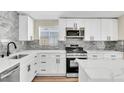 Modern kitchen with white cabinets, stainless steel appliances, and marble countertops at 3212 Hickey Ave, North Las Vegas, NV 89030
