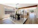 Bright dining room with modern lighting, wood beam, and an open layout to the kitchen and backyard at 356 Gulfport Ct, Las Vegas, NV 89145