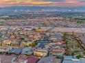 Expansive aerial view of a well-planned community showcasing rooftops and city views against a sunset backdrop at 365 Crown Mesa Ave, Las Vegas, NV 89138