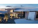 A modern home's unique exterior features a circular design element, contrasting textures, and manicured landscape, creating curb appeal at 4 Horseshoe Rock Ct, Henderson, NV 89012