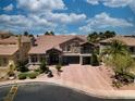 Aerial view of a stucco two-story home with brick driveway, tile roof, landscaping, and two-car garage at 4108 Royal Scots Ave, Las Vegas, NV 89141