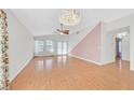 Spacious living room with stylish chandelier, ceiling fan, light wood floors, and large windows at 5429 Sweet Shade St, Las Vegas, NV 89130