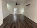 Inviting living area featuring dark flooring, neutral walls, and ample natural light from the front door at 5591 La Perla Ct, Las Vegas, NV 89122