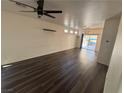 Bright living room features dark wood-look floors and abundant natural light from the sliding glass door at 5591 La Perla Ct, Las Vegas, NV 89122