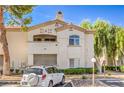 Exterior view of a condo building featuring assigned parking, desert landscaping, and a stucco facade at 6480 Annie Oakley Dr # 624, Las Vegas, NV 89120