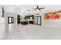Spacious living room and kitchen with white tile flooring and stainless steel appliances at 8021 Yellow Daisy Ave, Las Vegas, NV 89147
