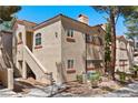 A two-story condo building with a sand-colored exterior, terracotta roof tiles, and exterior stairway at 8409 Running Deer Ave # 203, Las Vegas, NV 89145