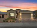Beautiful single-Gathering home featuring desert landscaping, brick accents, and a two-car garage at sunset at 8668 Hartmont St, Las Vegas, NV 89166