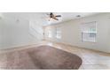 Spacious living area with neutral tile flooring, a ceiling fan, and large windows at 8872 Perfect Diamond Ct, Las Vegas, NV 89129