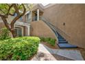 Charming two-story condo featuring stucco facade, stairs to front door, white columns, and mature landscaping at 9112 Vista Greens Way # 204, Las Vegas, NV 89134