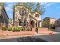 Inviting two-story home featuring a red door, stone accents, and a well-maintained landscape at 10917 Mount Pendleton St, Las Vegas, NV 89179