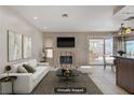 Cozy living room with fireplace, TV, plush seating, and sliding glass doors to backyard at 1219 Heather Oaks Way, North Las Vegas, NV 89031