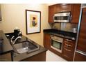 Kitchenette featuring stainless steel appliances and a sleek sink with stainless steel faucet at 145 E Harmon Ave # 27621, Las Vegas, NV 89109
