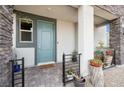 Charming front porch featuring a blue door, decorative plants, and stone accents at 1474 Whistling Kite St, Las Vegas, NV 89138
