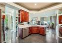 Spacious kitchen featuring dark wood cabinets, stainless steel appliances, and a view into the dining area at 1609 Hidden Spring Dr, Las Vegas, NV 89117