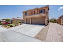 A two-story home exhibits a spacious two-car garage complemented by meticulous landscaping and a brick-paved walkway at 1699 Sonoran Bluff Ave, Henderson, NV 89014