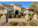 Inviting facade with an arched entryway, double doors, and meticulously kept landscaping that adds to the home's curb appeal at 2111 Bogart Ct, Las Vegas, NV 89117