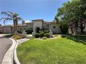 Lush front yard with manicured lawn, mature trees, and landscaping enhances the curb appeal of this beautiful home at 2111 Bogart Ct, Las Vegas, NV 89117