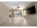 Expansive living room showcasing tile flooring, neutral walls, a ceiling fan, and backyard views at 2708 Cheer Pheasant Ave, North Las Vegas, NV 89084
