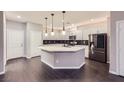 Modern kitchen boasts a large island, sleek countertops, stainless appliances, and stylish pendant lighting at 2878 Via Firenze, Henderson, NV 89044