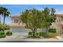 Exterior view of home showcasing desert landscaping and two-car garage at 301 Lakewood Garden Dr, Las Vegas, NV 89148
