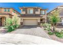 Two-story home featuring a two-car garage, desert landscaping, and a brick driveway with sidewalk access at 330 Spring Dove Ave, Henderson, NV 89011