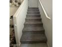 Carpeted staircase with a white handrail provides a smooth transition between the floors at 330 Spring Dove Ave, Henderson, NV 89011